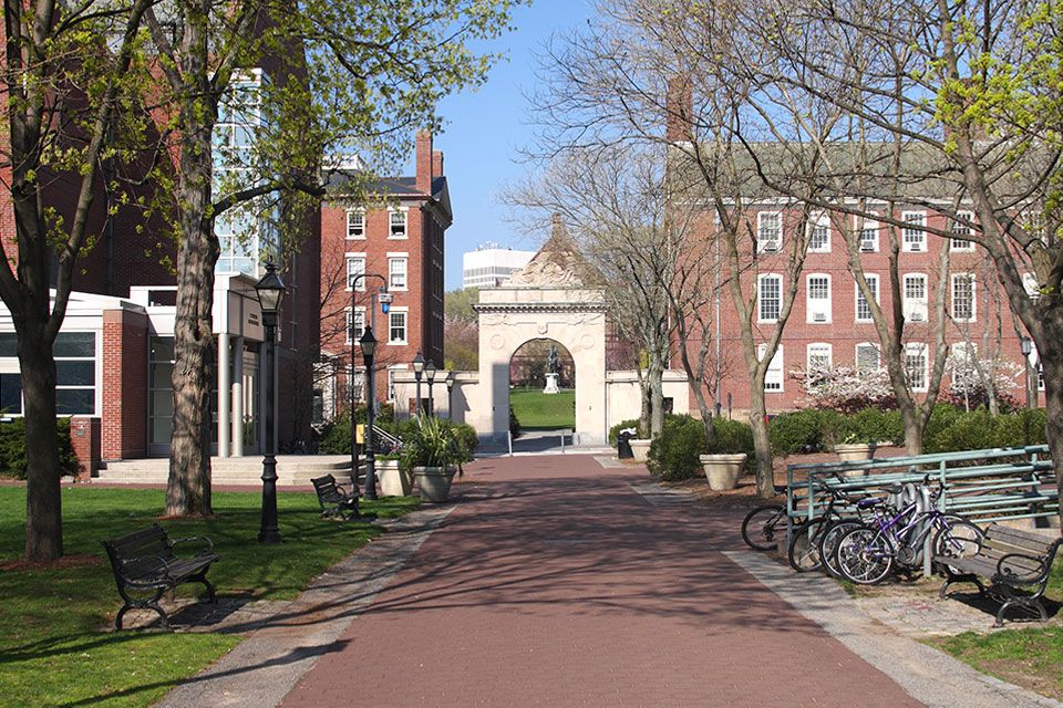 outdoor college campus walkway leading to large historical campus buildings