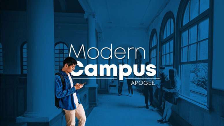 Student browsing looking at smartphone while leaning on column in hallway of a modern campus