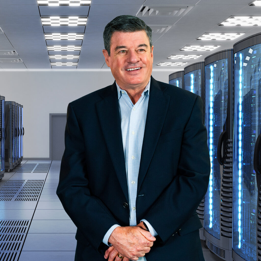a person in a suit stands in front of server racks