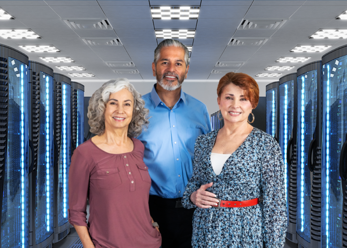 Bearded man with two women in front of two rows of servers