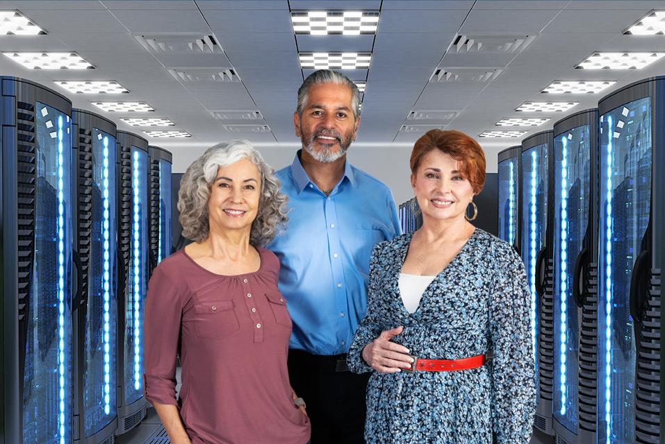 Bearded man with two women in front of two rows of servers