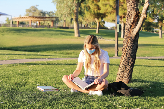 Girl reading in park. The grass is very green